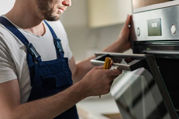 Technician using a tablet while inspecting a built-in oven