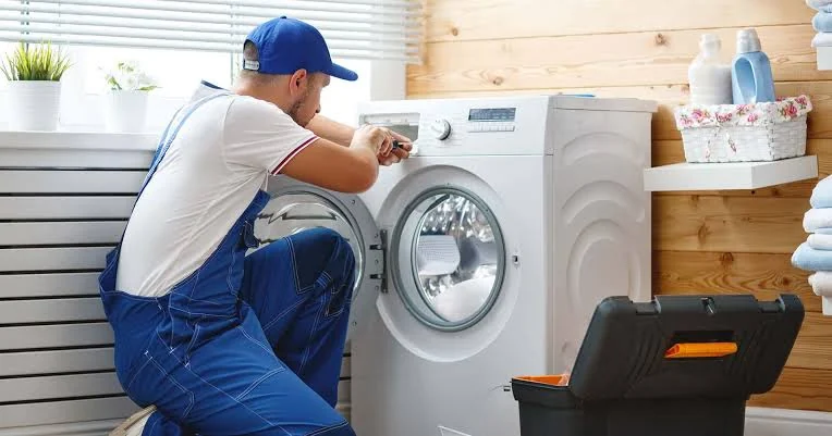Technician repairing the control panel of a front-loading washing machine