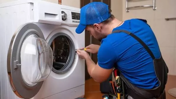 Technician examining the door opening and drum of a washing machine